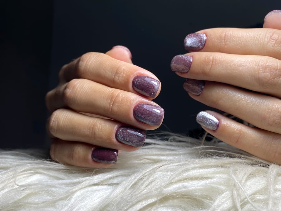 Uñas cortas con esmaltado semipermanente efecto ojo de gato en malva y destellos plateados, hechas en Nails by Mery